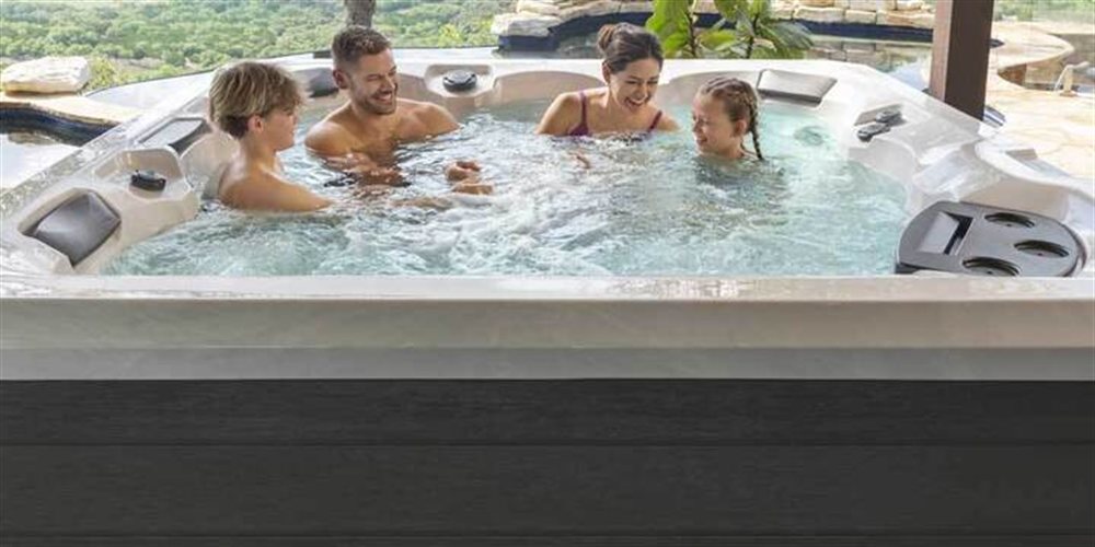 Family relaxing in a Legacy Series hot tub.
